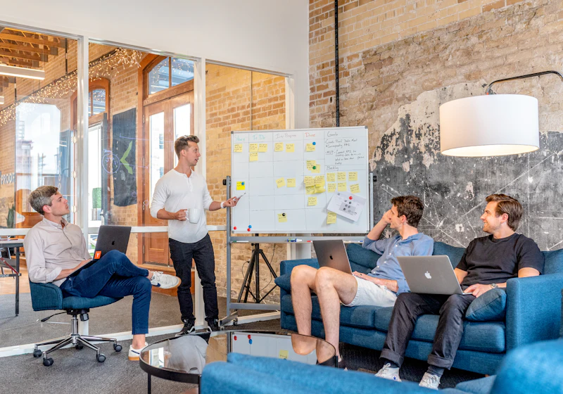 A facilitator leading a whiteboard workshop with a small team