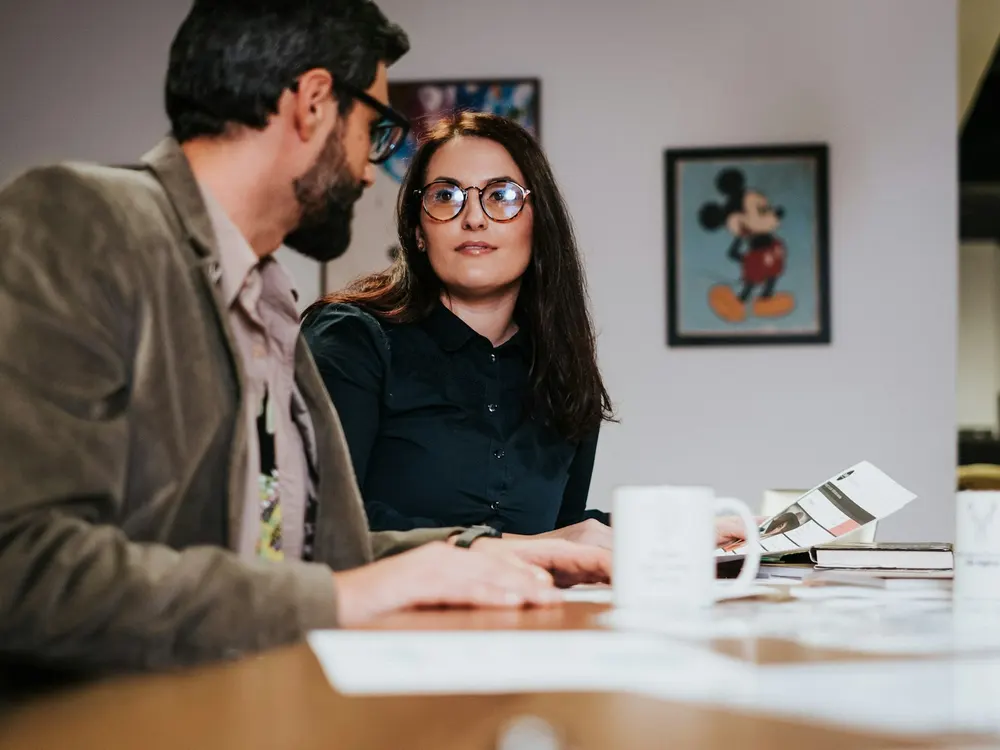 Two professionals reviewing materials together at a table