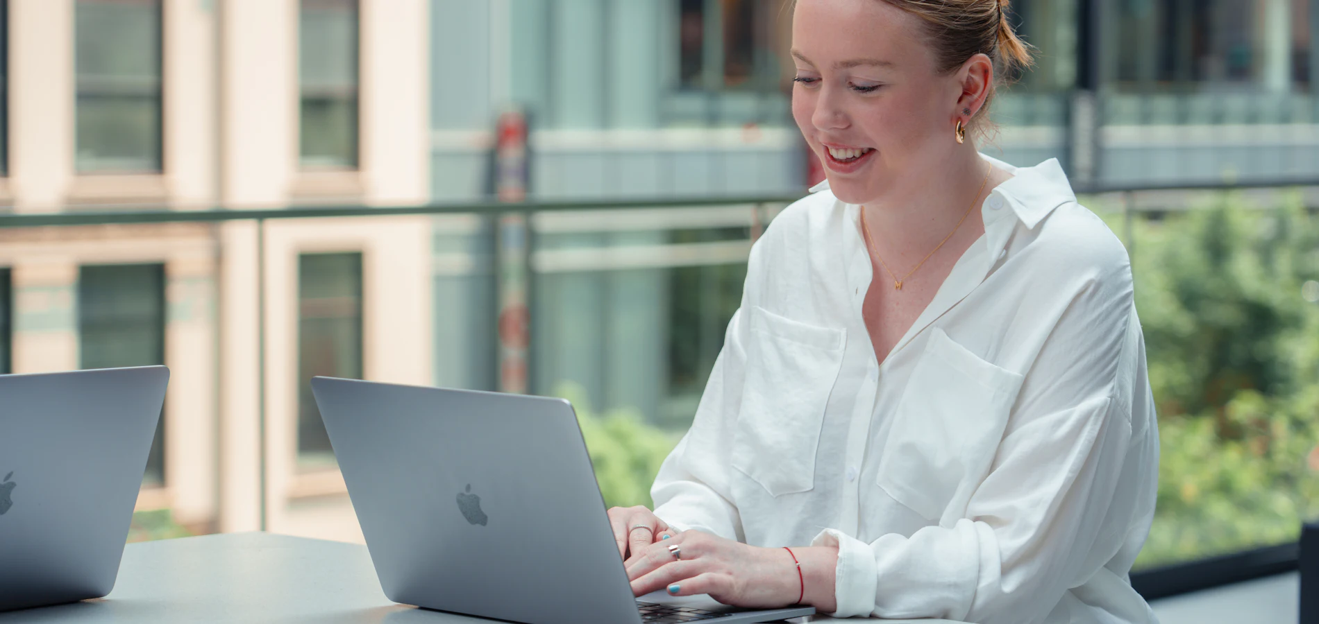A professional working through an online course on her laptop by a bright window