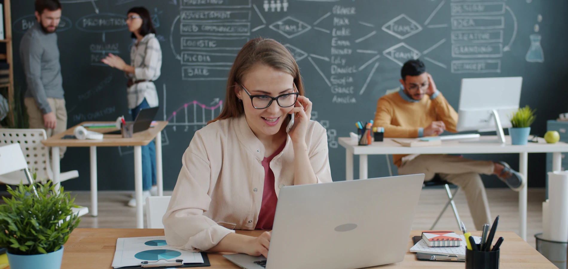 A professional speaking on the phone at her desk